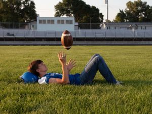 becky katzberg photography  senior boy on football field tossing a football