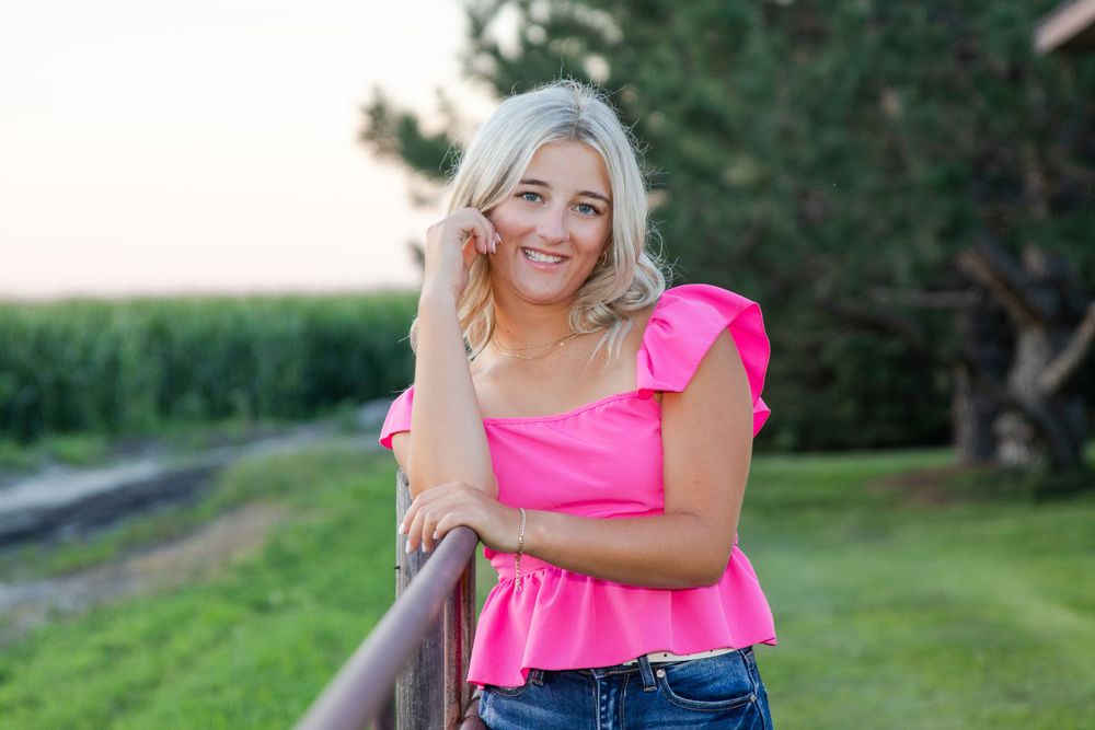 becky katzberg photography senior girl in bright pink by edge of cornfield