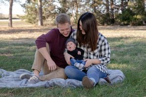becky katzberg photography new family with 1 month old baby parents looking at baby and smiling