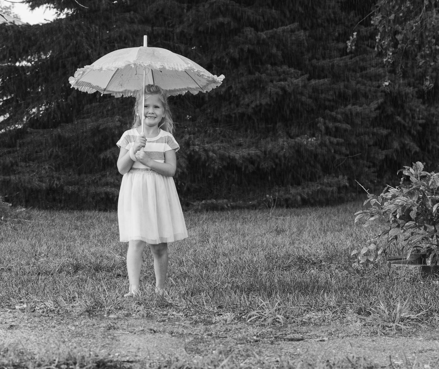 becky katzberg photography young girl walking in the rain with her umbrella black and white