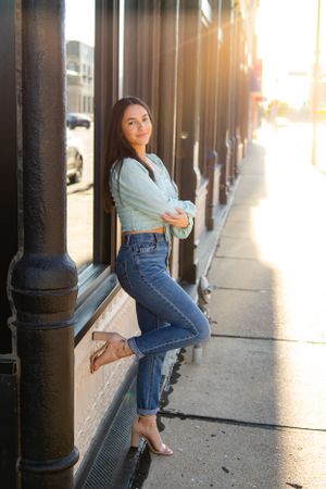 becky katzberg photography senior girl on a sunny sidewalk wearing jeans and high heals