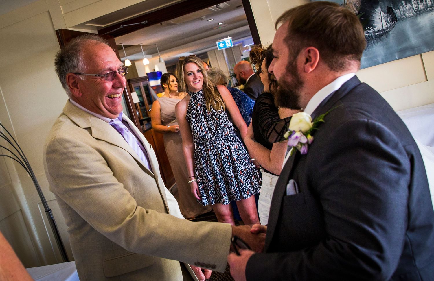 Candid moments captured during wedding reception with guests in formal attire.