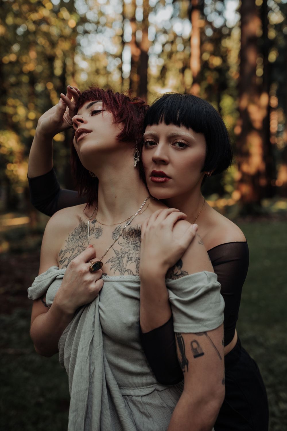 Dramatic outdoor photoshoot showing intimate poses against a forest backdrop at golden hour.