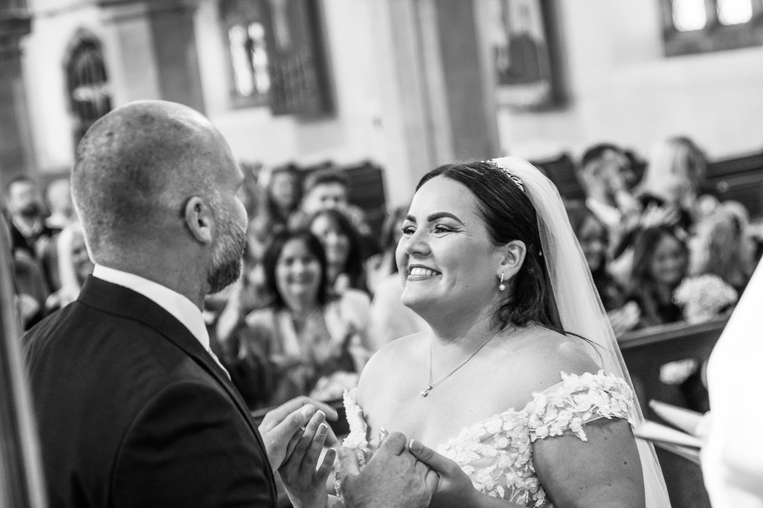 Wedding ceremony moment with guests in attendance at indoor venue.
