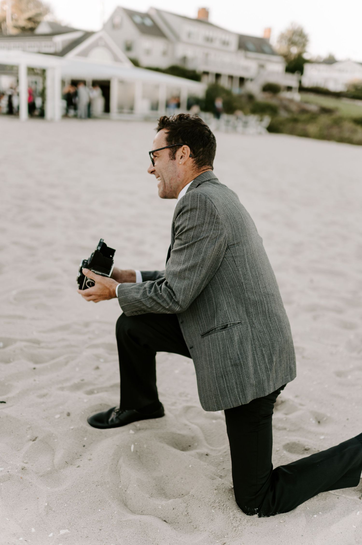 Professional photographer captures moments on beach during sunset.
