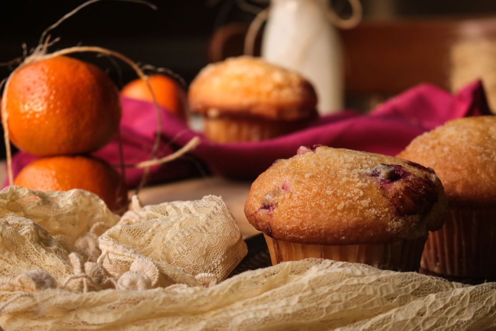 Fresh citrus fruits and baked goods arranged on textured fabric.