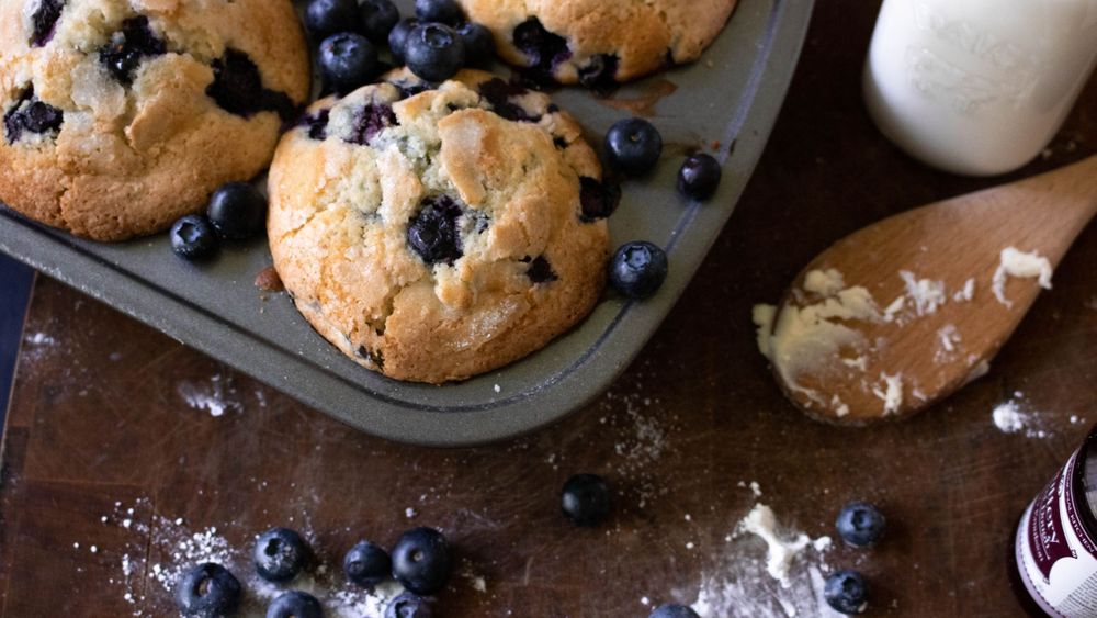 Homemade chocolate chip cookies with fresh blueberries scattered around.