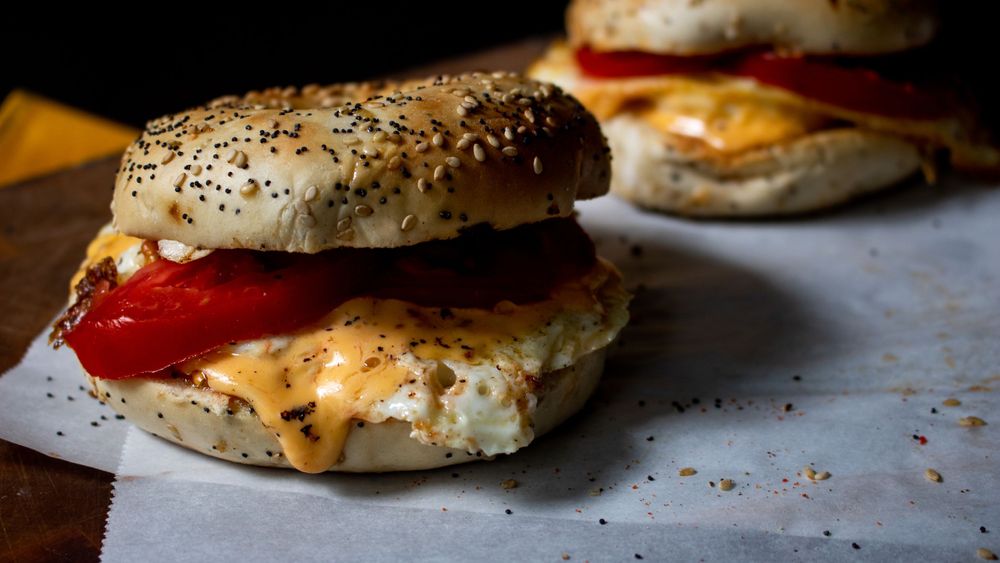 Close-up of freshly baked pastries with melted cheese and seasonings on a dark background.