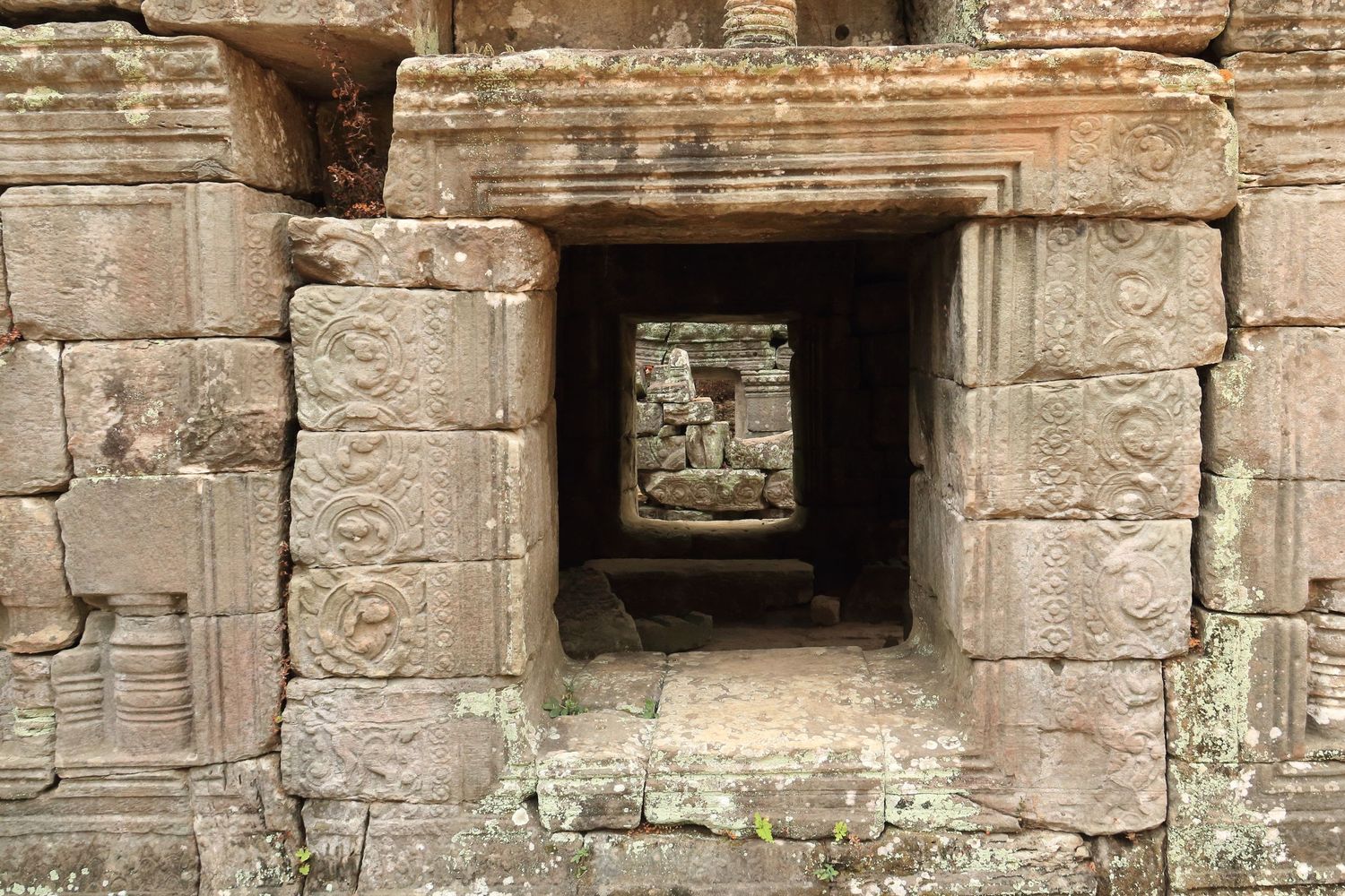 Ancient stone doorway showing architectural details of an Angkor temple corridor.