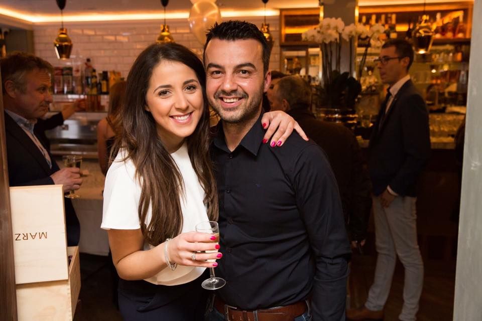 Couple enjoying drinks together at casual restaurant bar setting.