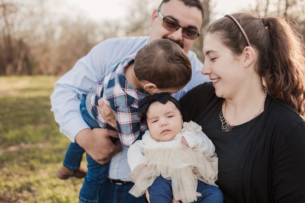 Family sharing an intimate moment together during an outdoor photoshoot.