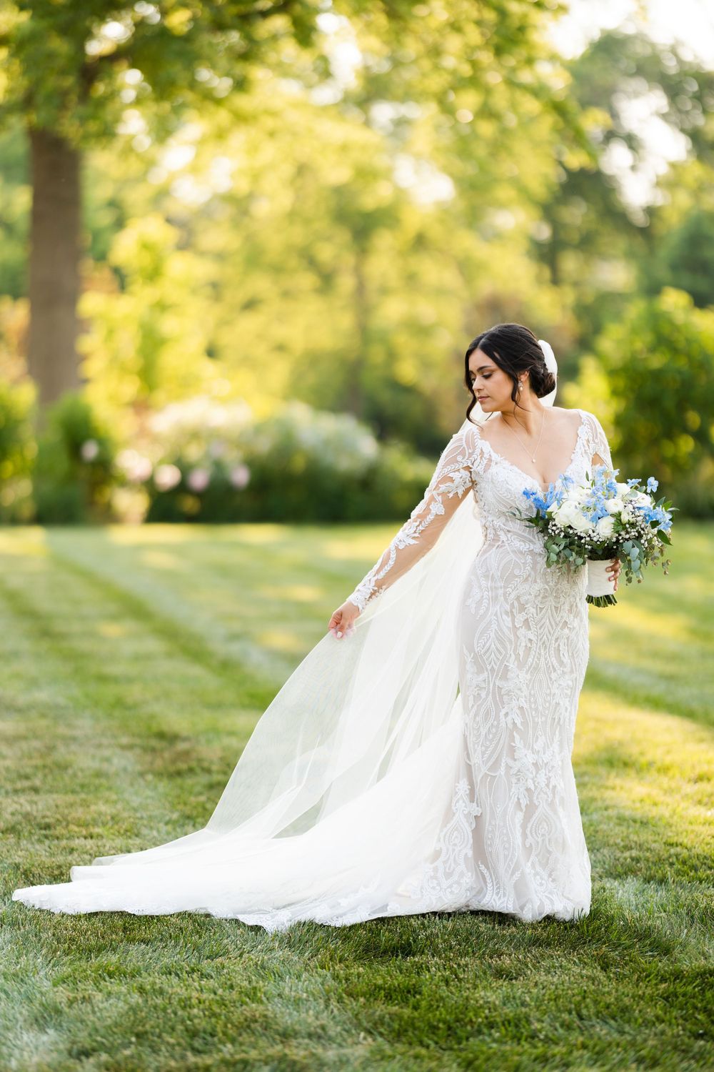 Bride adjusts veil during relaxed portrait on wedding day at Jorgensen Farms in Westerville, Ohio.