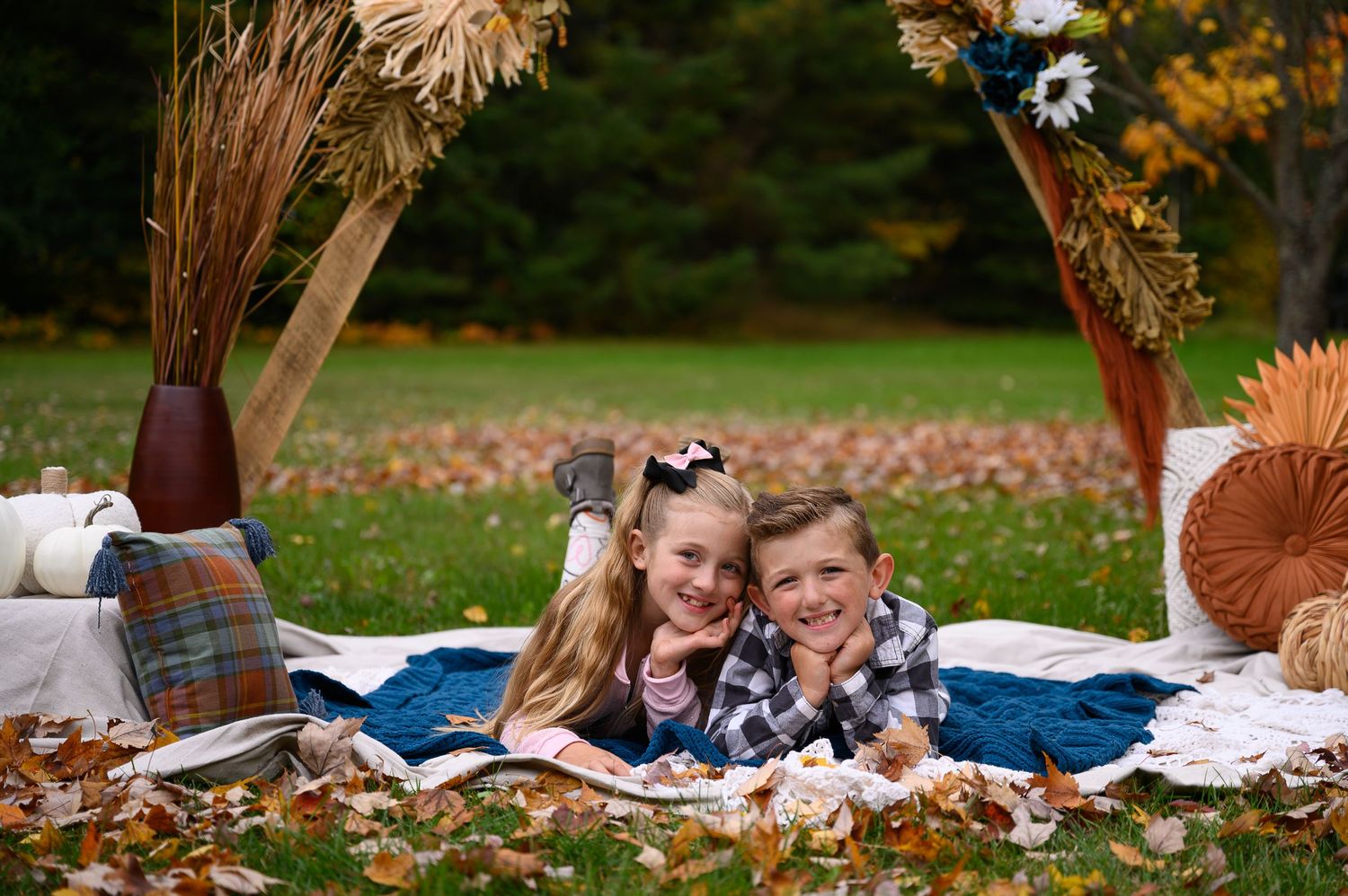 Two children pose on fall harvest scene for kids photoshoot in Orr, MN.