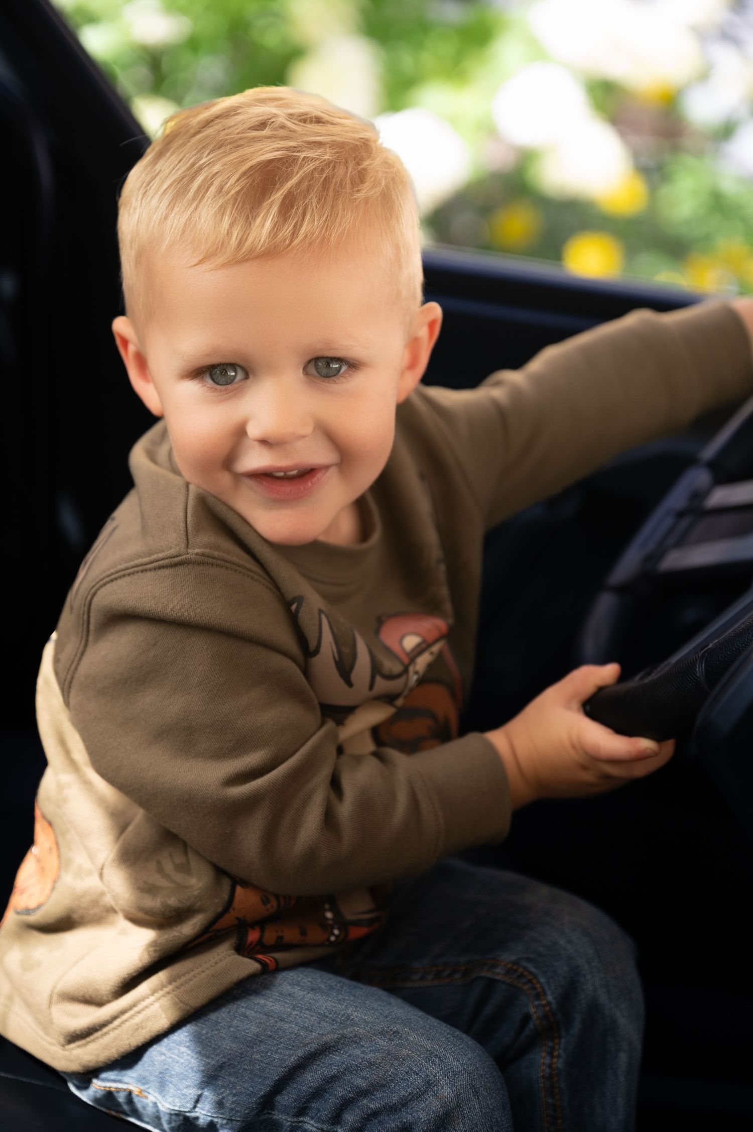 Young boy riding in truck posing for photo in Orr, Minnesota.
