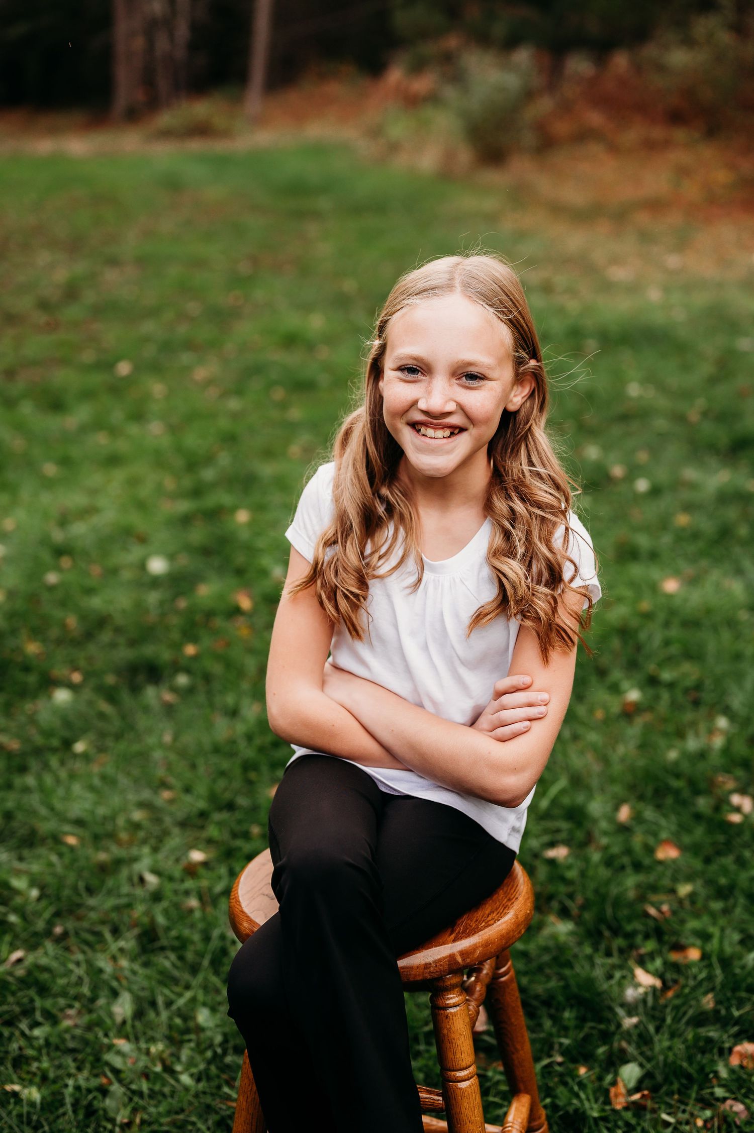 Girl in white shirt posing on stool in Orr, Minnesota.