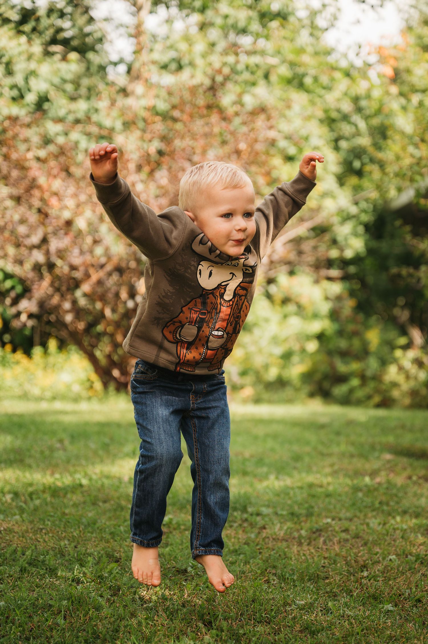 Young boy jumping for kids photo shoot in Orr, Minnesota.