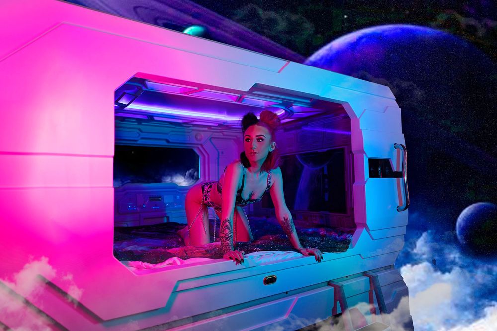 Neon-lit photo shoot in a vintage camper with pink and blue lighting.