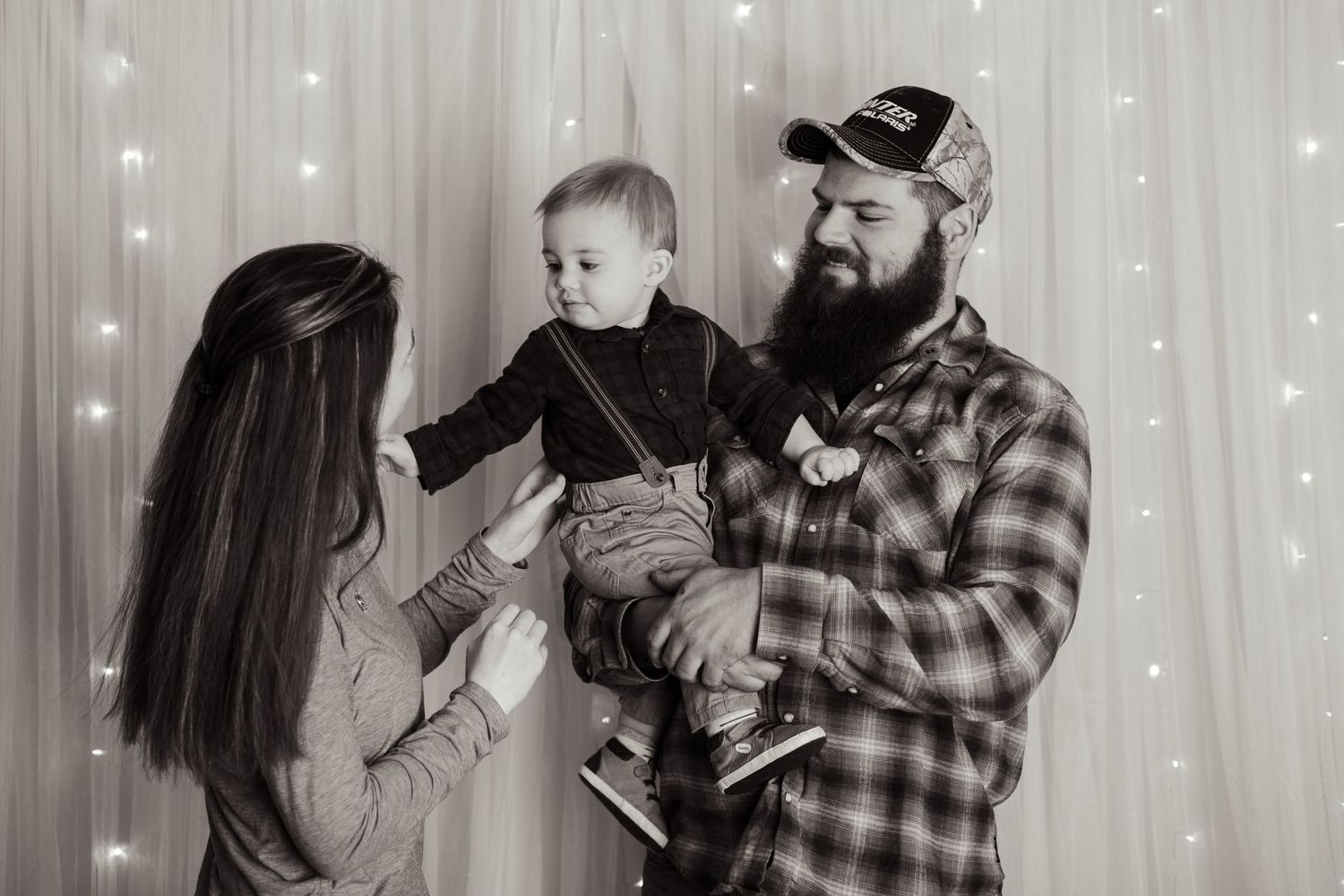Black and white photo of family moment against sparkly backdrop.