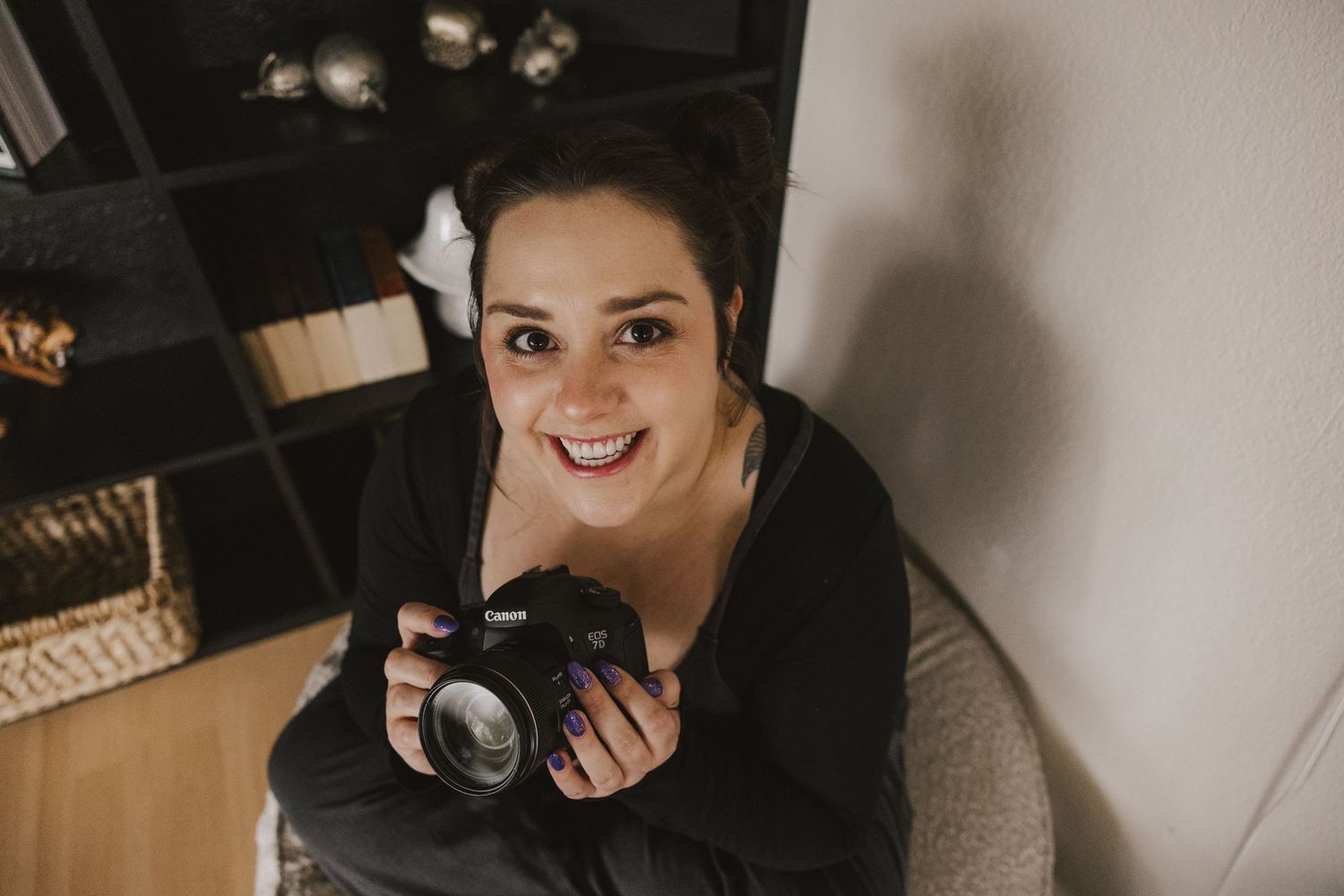 Indoor portrait of photographer with natural lighting holding camera and smiling. Denver Photographer.