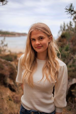 Casual winter portrait in cream sweater with natural coastal backdrop.