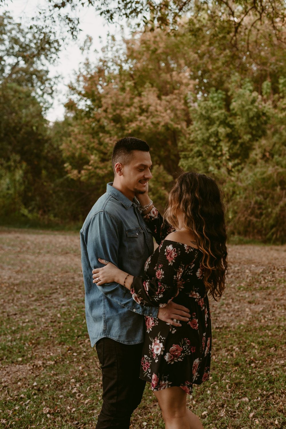 Happy couple laughing together during sunset photoshoot in nature.