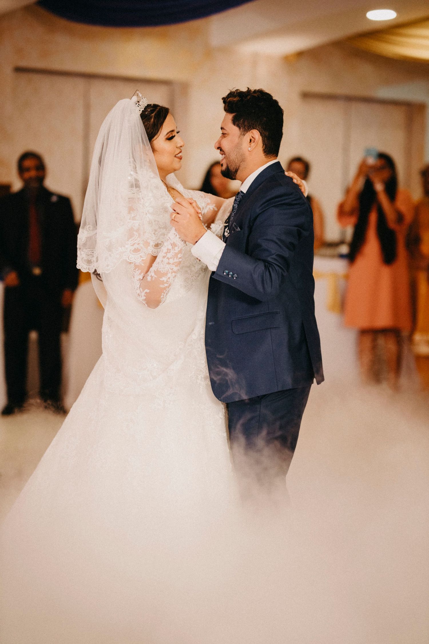 Romantic dance moments captured at an indoor wedding reception with soft lighting.