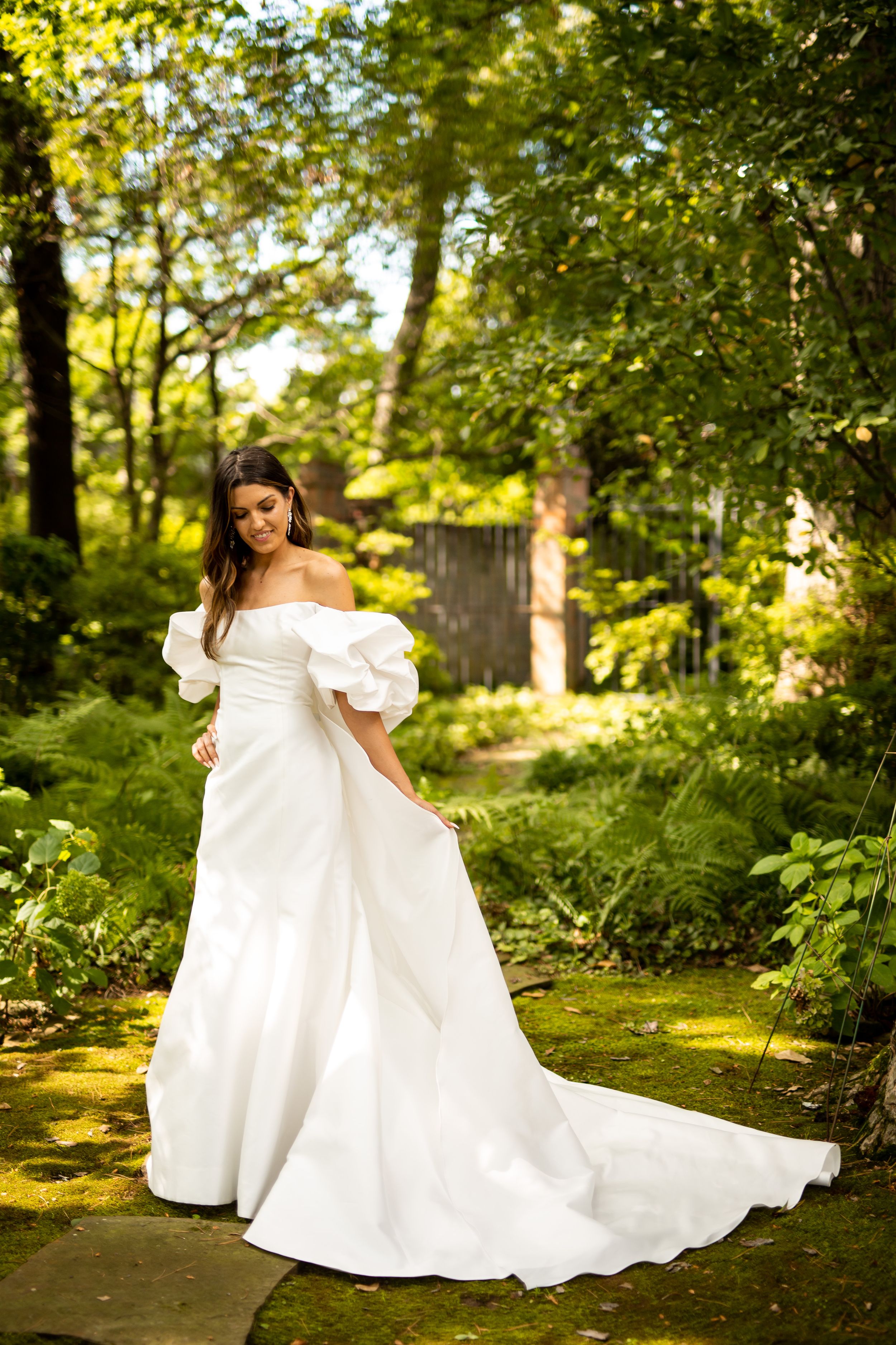 Romantic bridal portraits featuring a flowing white wedding gown in a sunlit garden setting.