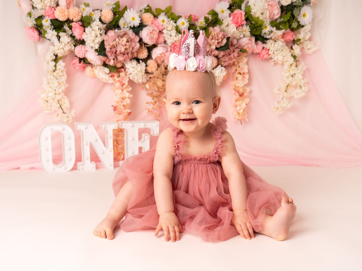 one year old first birthday baby girl cake smash session with florals by professional newborn photographer in Doncaster.