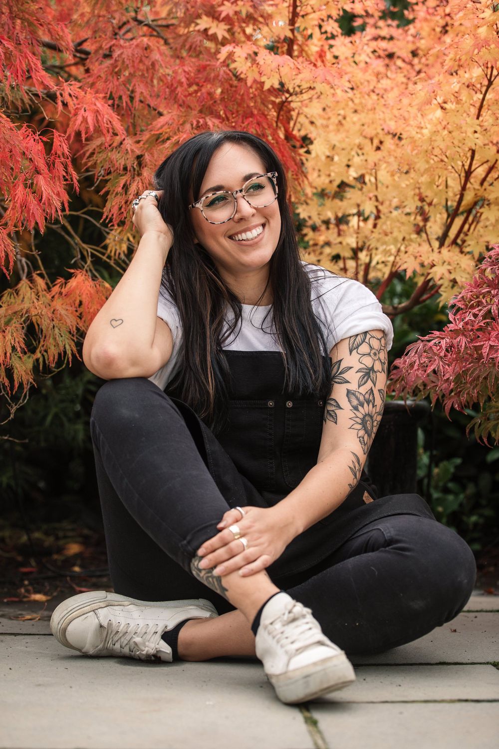 Brand Photographer in Hertfordshire Becky Harley Creative Annie smiling sat in front of autumnal coloured leaves