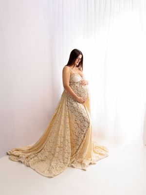 Fine art maternity photography in New Hampshire of a pregnant woman in a cream lace gown, softly lit studio portrait highlighting motherhood