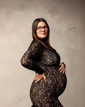 Studio maternity photography in New Hampshire showcasing a pregnant woman in a black lace gown, timeless fine art pregnancy portrait