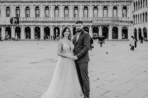 Ein Hochzeitsporträt vor historischer italienischer Architektur mit klassischen Bögen.