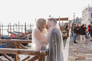 Ein romantischer Moment am venezianischen Kanal mit Gondeln im Hintergrund.