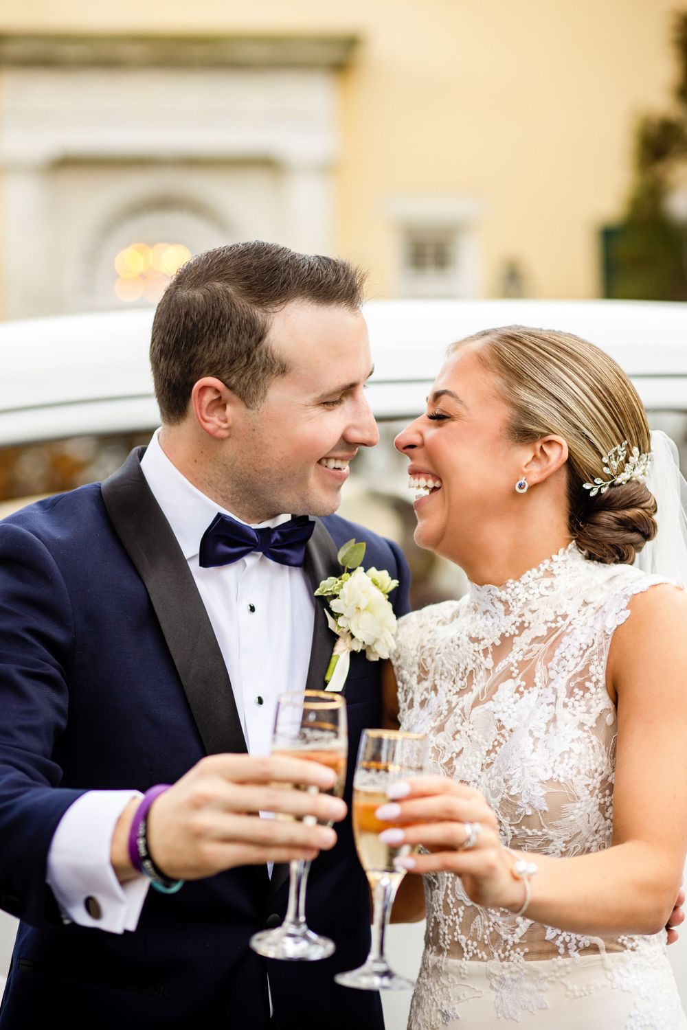 A joyful couple shares champagne and laughter during their wedding celebration.