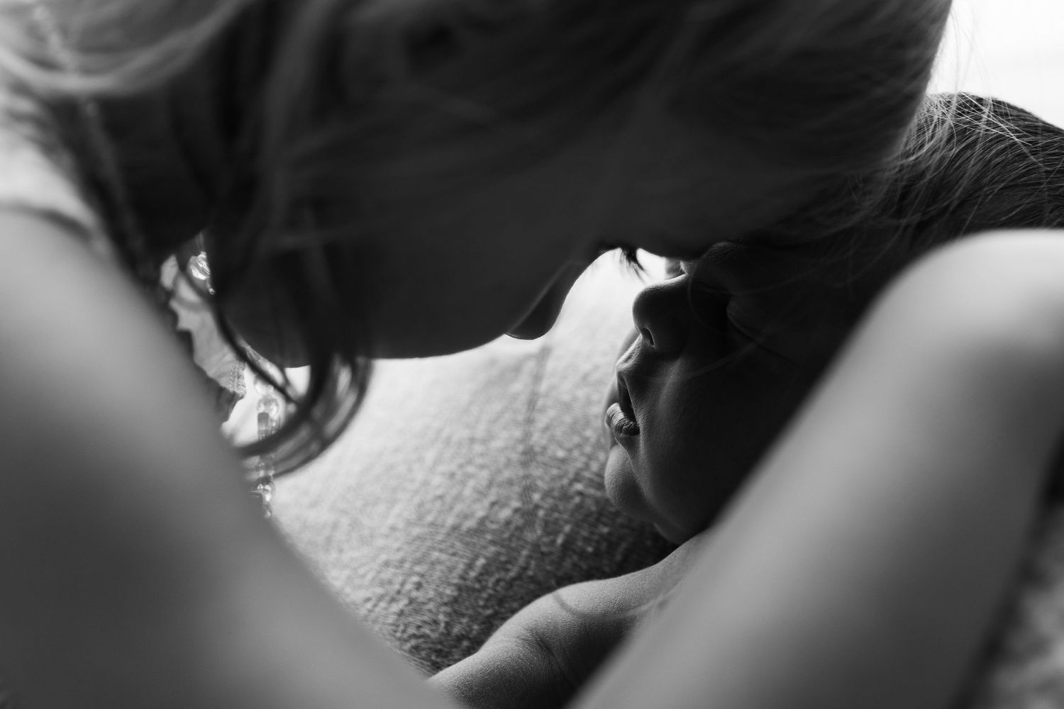Black and white close-up of intimate newborn photography moment.