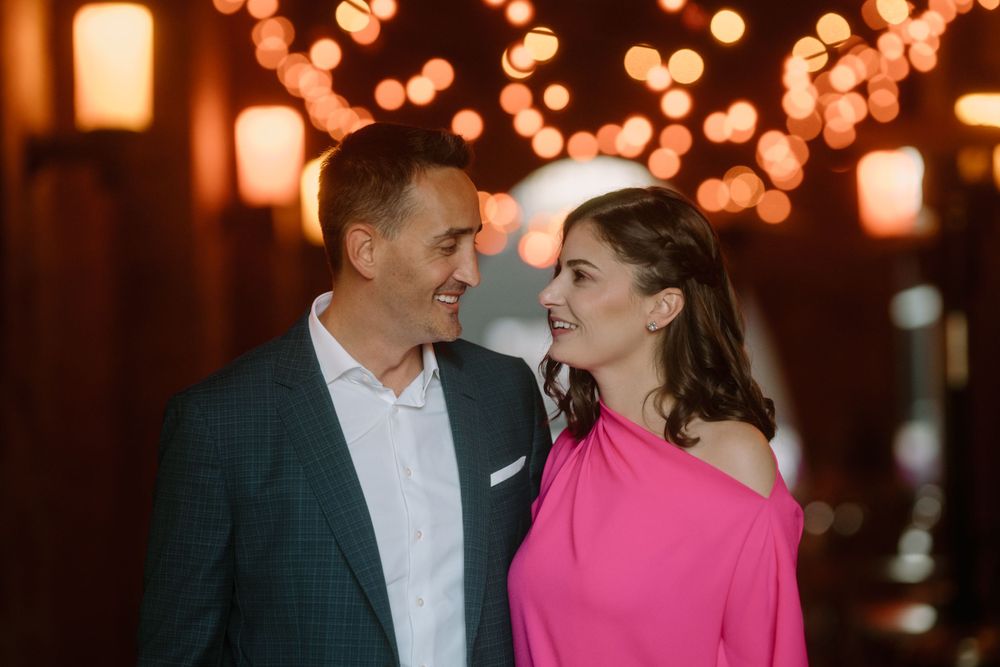 Elegant couple sharing tender moment under warm string lights.