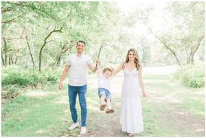 A small group enjoying a playful moment on a wooded path in coordinated white outfits.