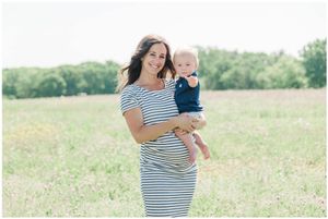 A striped dress creates a bright outdoor portrait in a sunny field surrounded by greenery.