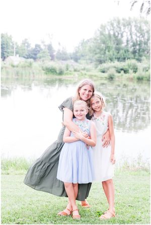 Three people share an intimate moment together by a tranquil pond.