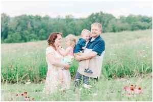 A loving family shares joyful moments together in a field of wildflowers.
