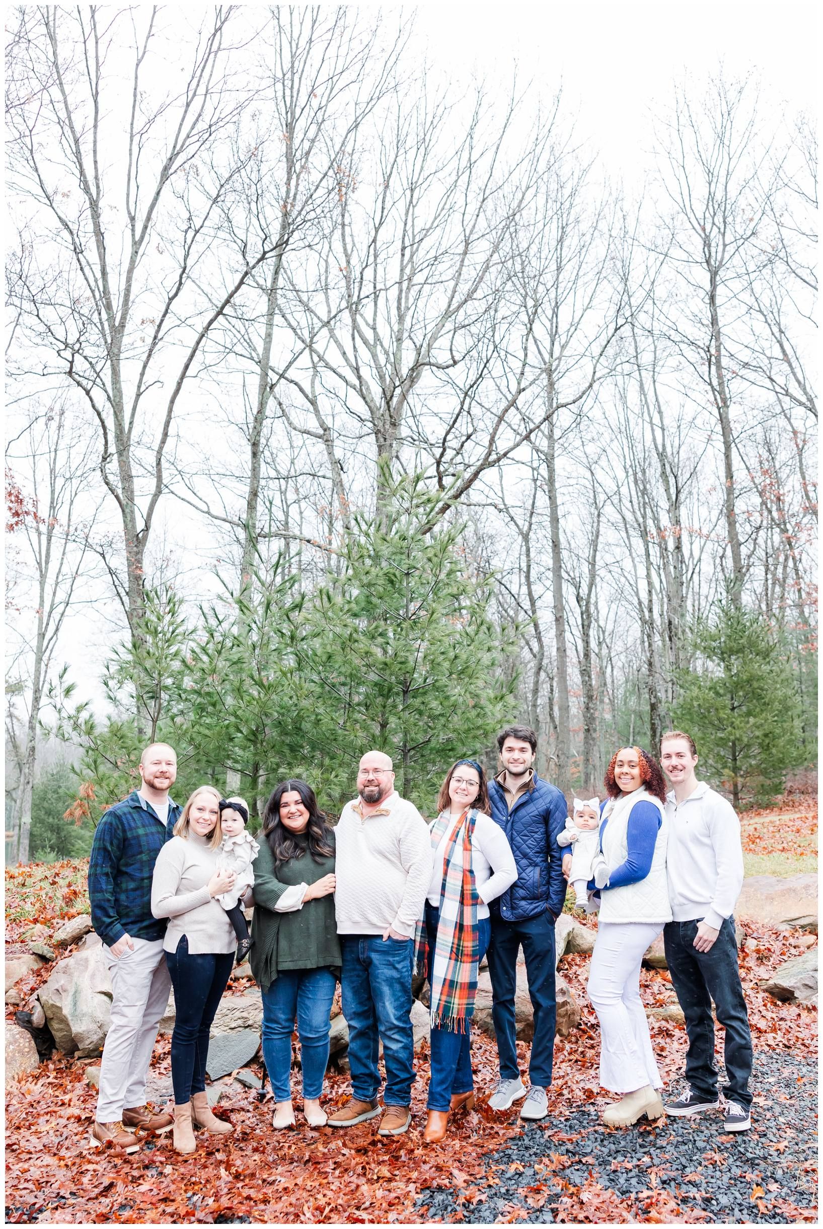 Group photo of people standing together on rocky ground with bare trees in background.