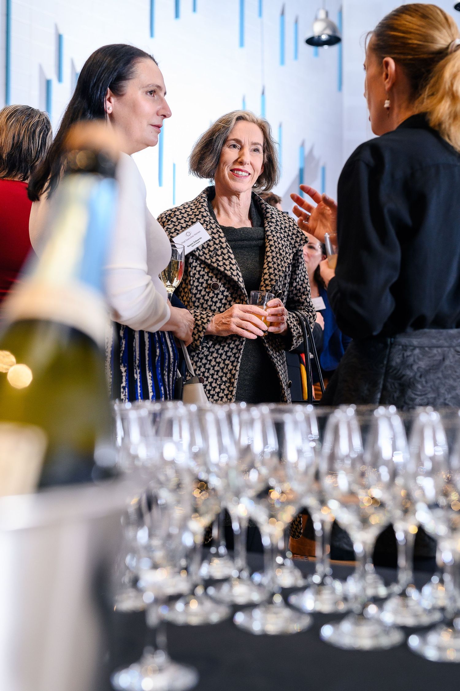 An elegant wine tasting event with rows of champagne glasses in the foreground.