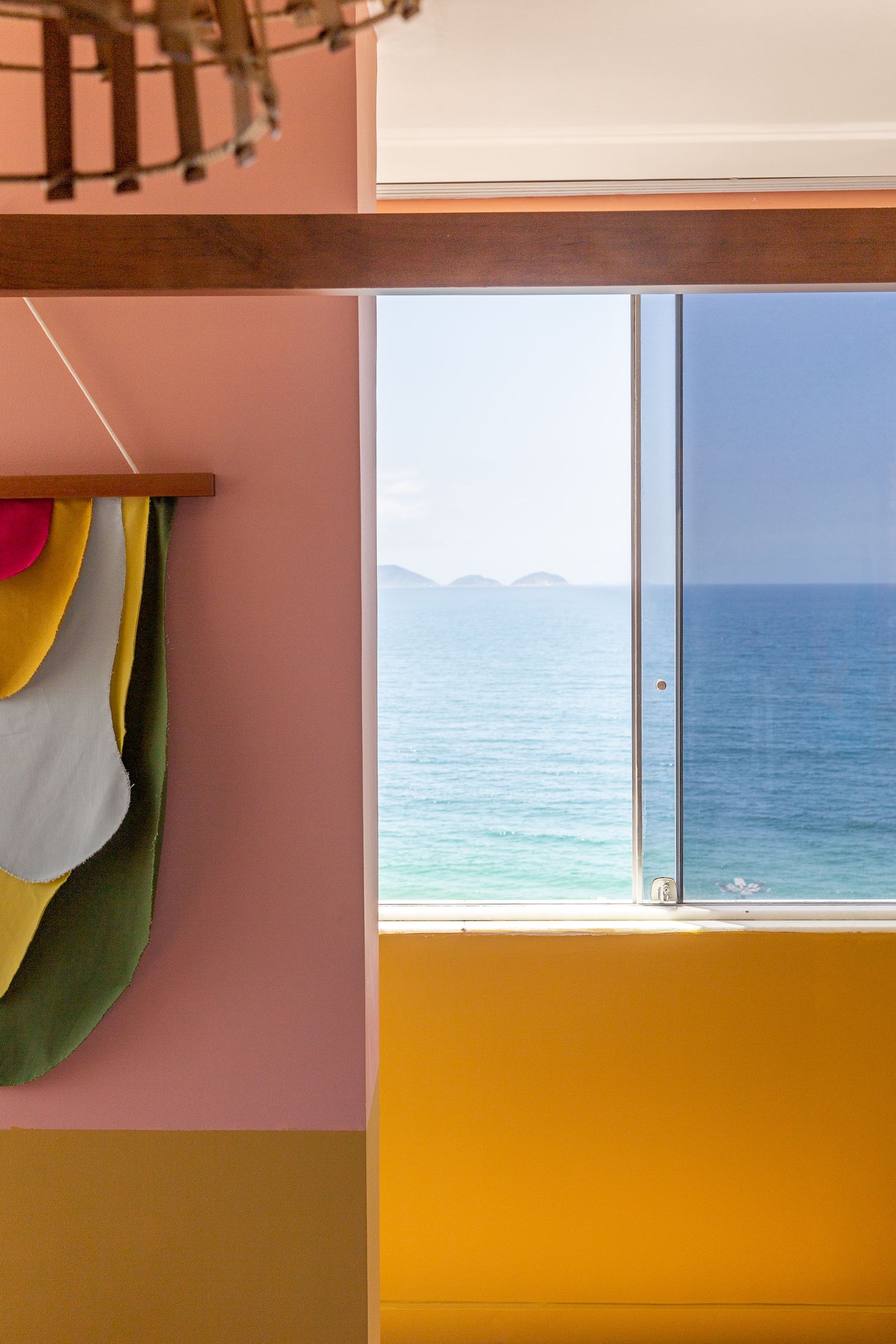 Artistic interior detail showing surfboard storage and ocean view through window.