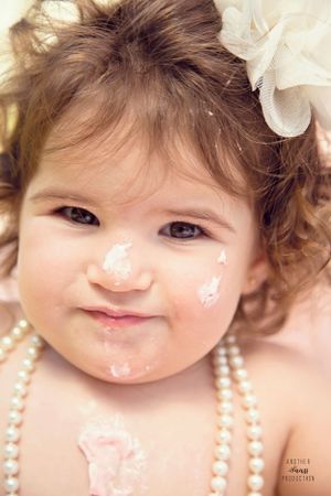 Close-up portrait series of baby wearing pearls and white lace dress.
