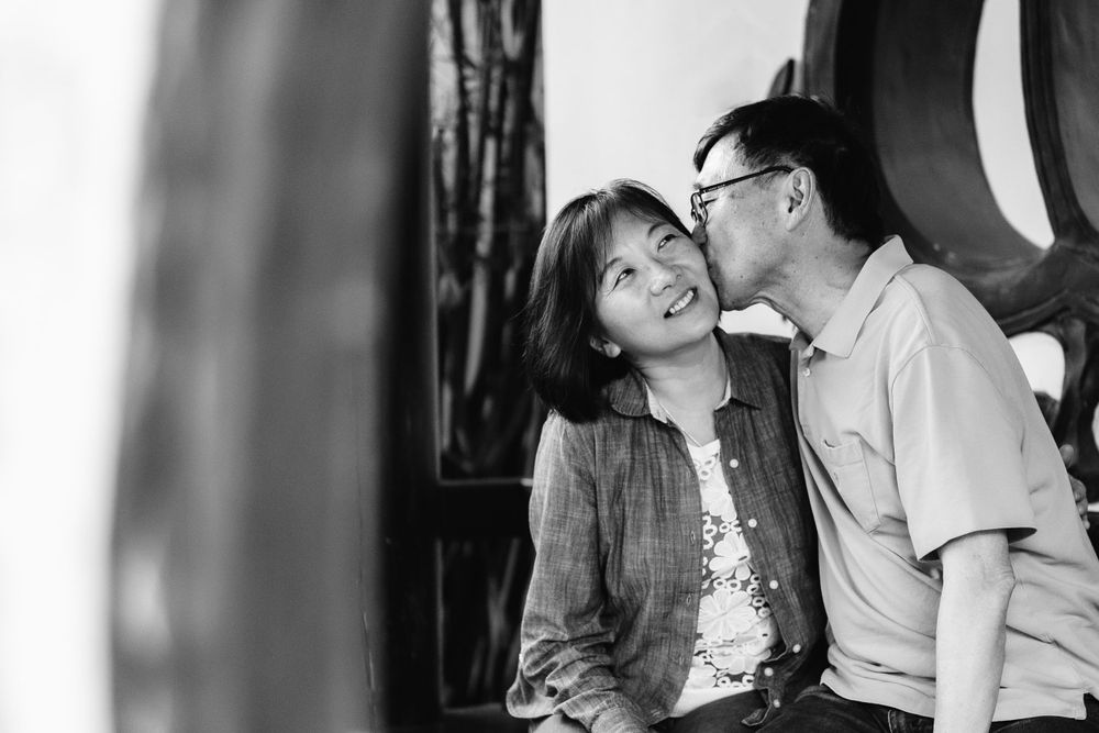 An intimate black and white portrait captured against an ornate architectural backdrop.