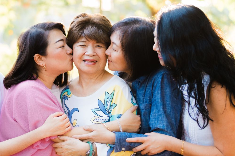 A joyful family moment captured outdoors with loving embraces and bright smiles.