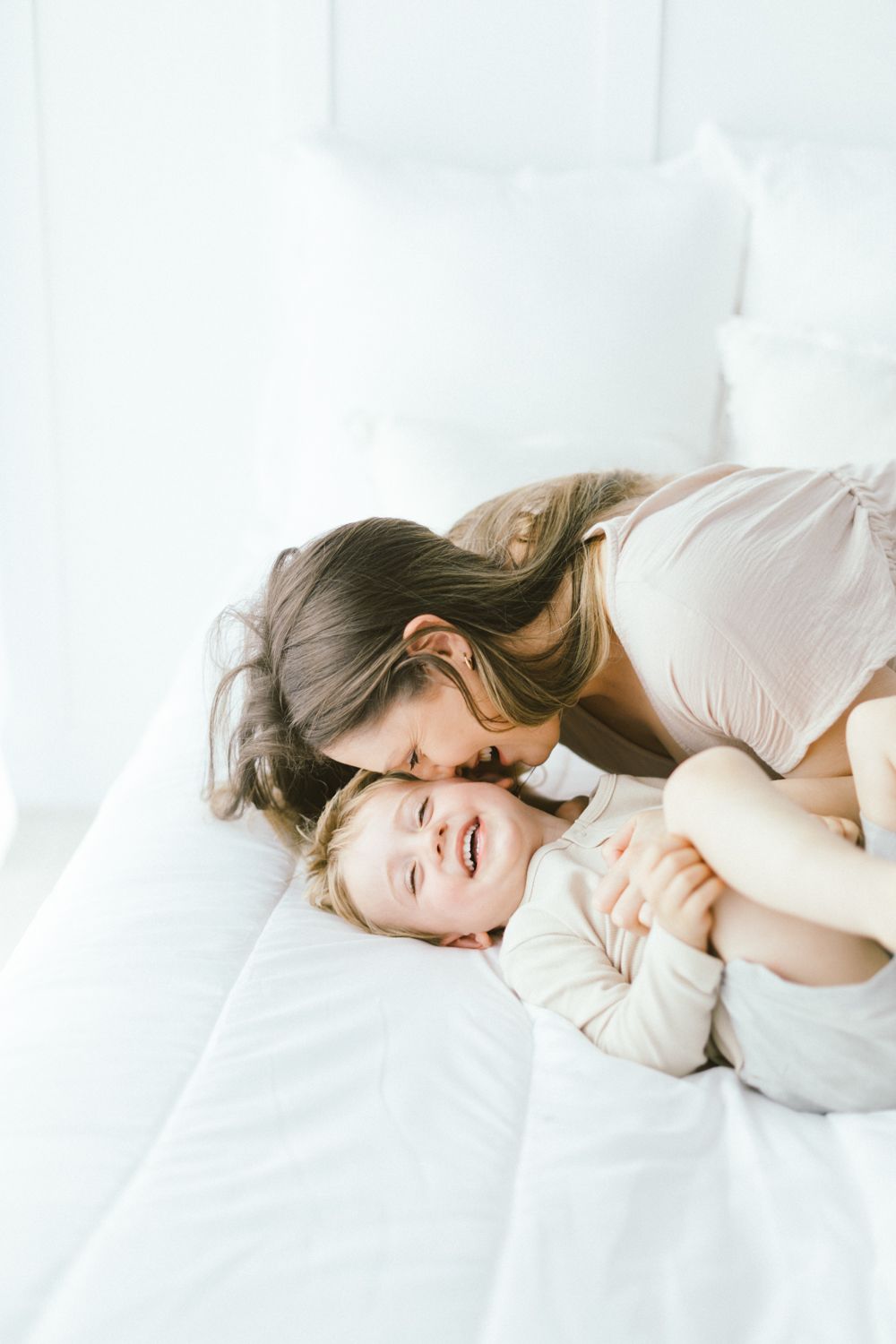 Playful family moment captured in bright, minimalist setting.