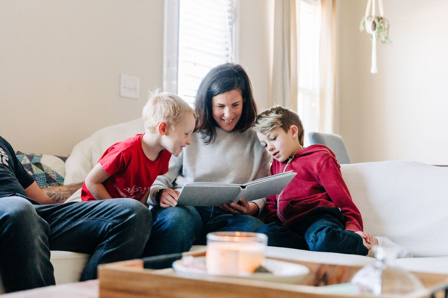 A mother looking at a photo album with her sons and smiling
