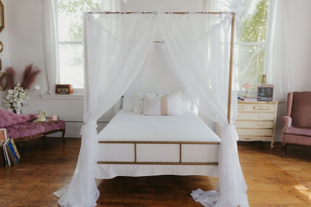 Bright white studio space with draped curtains, natural lighting, and hardwood floors.