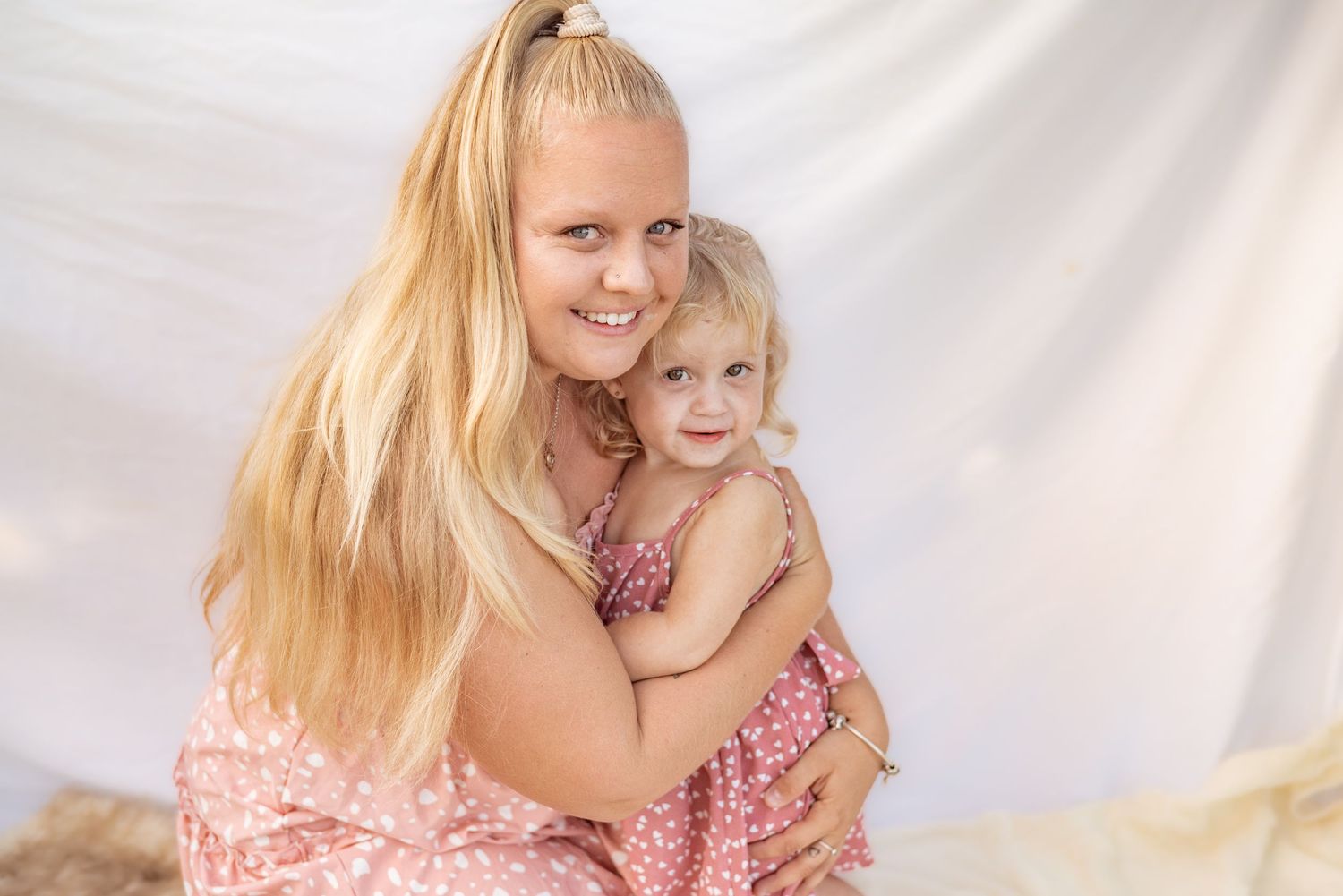A heartwarming studio portrait with soft lighting and white backdrop.